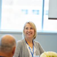 woman smiles during luncheon discussion